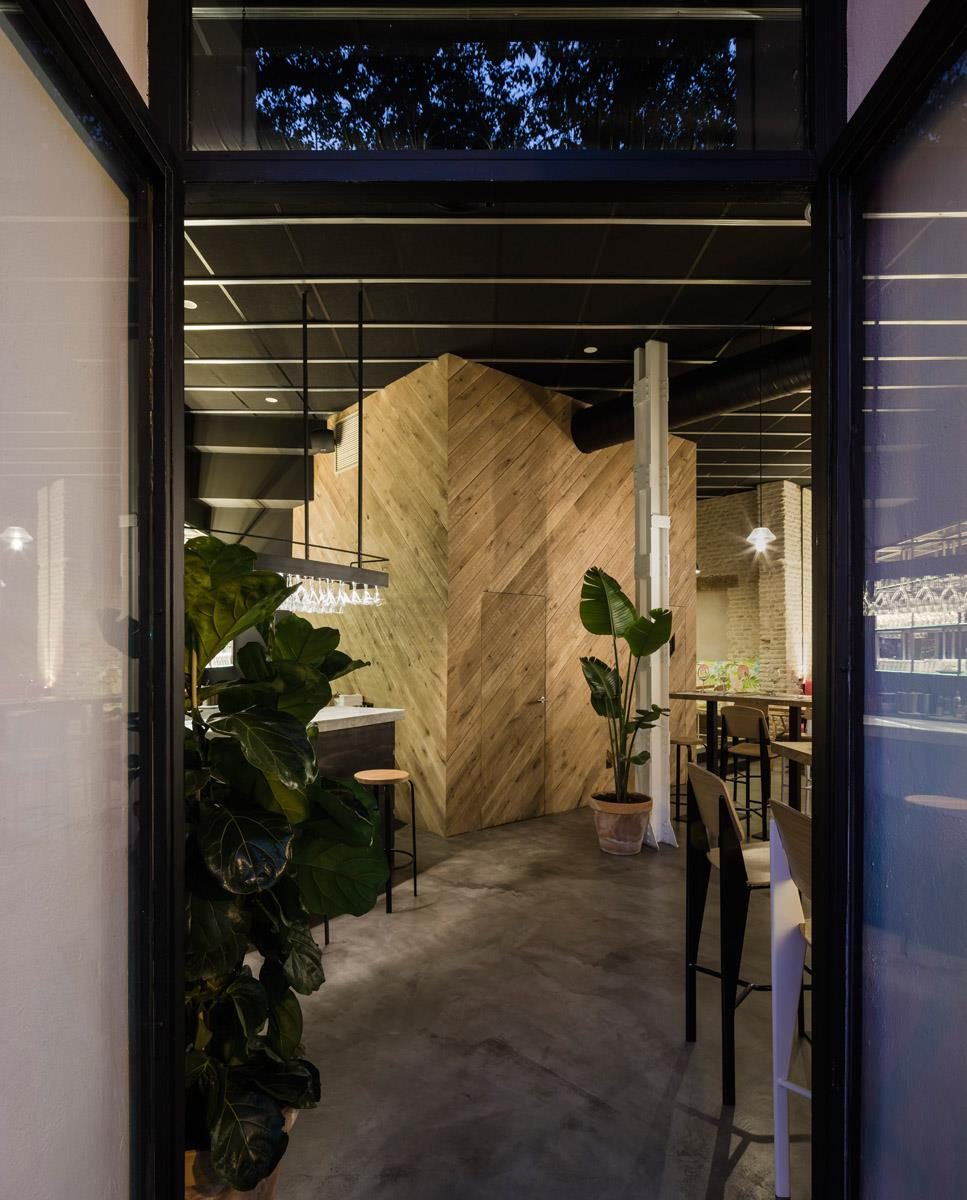 Entrada al local con plantas y madera